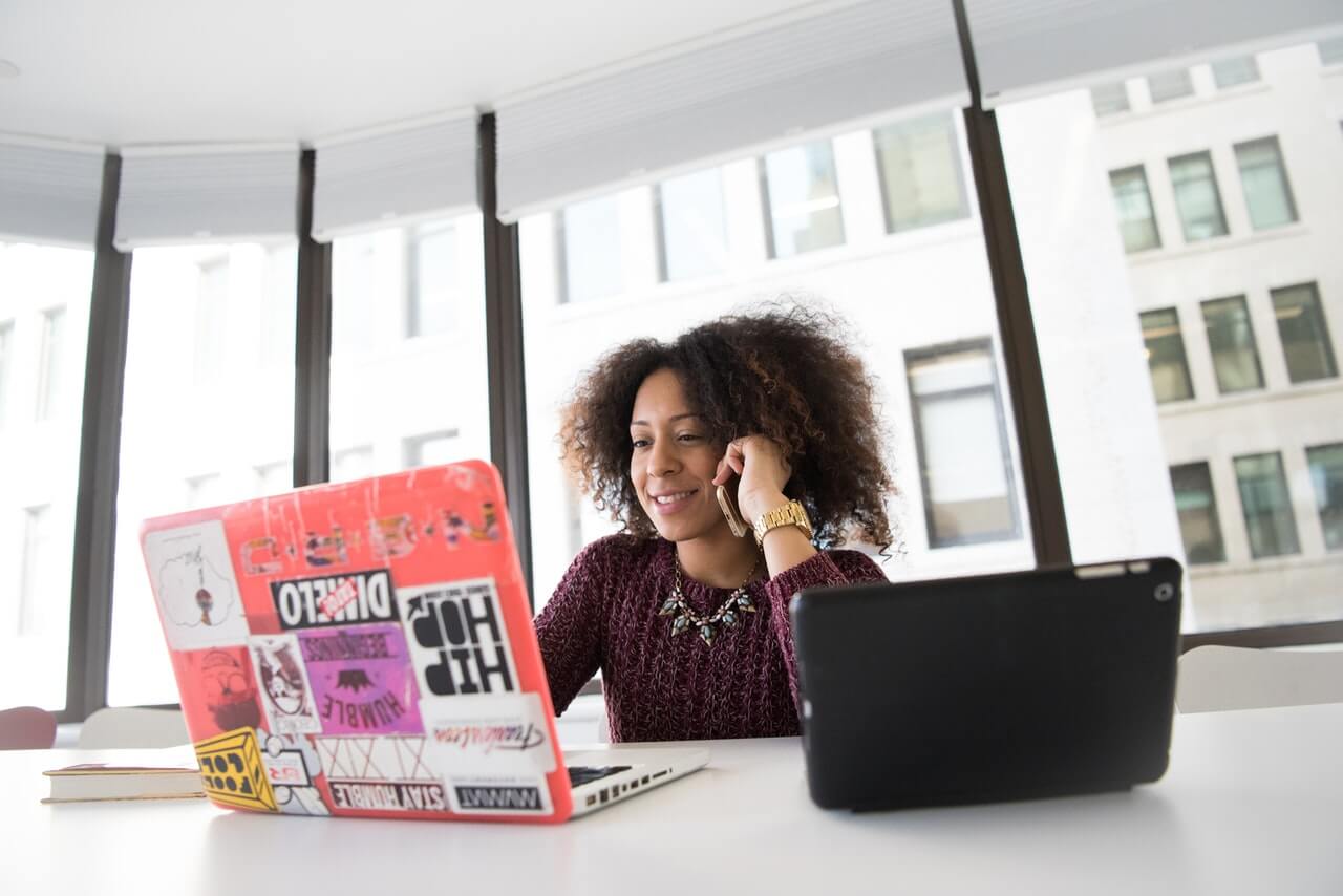 Jeune femme entrepreneur africaine, manipulant un ordinateur pc portable dans un bureau
