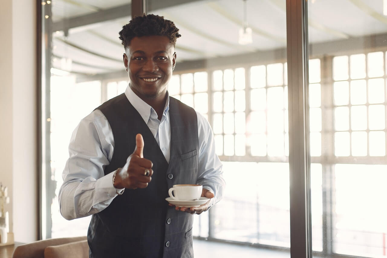 jeune entrepreneur africain souriant avec tasse de café